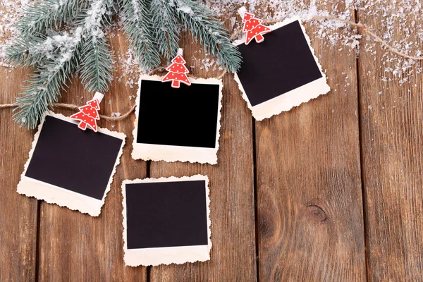 Marcos de fotos en blanco y decoración de Navidad con abeto de nieve sobre fondo de mesa de madera — Foto de Stock