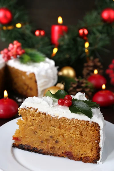 Kawałek ciasta pokryte krem z Bożego Narodzenia ozdoba na drewnianym stole tło — Zdjęcie stockowe