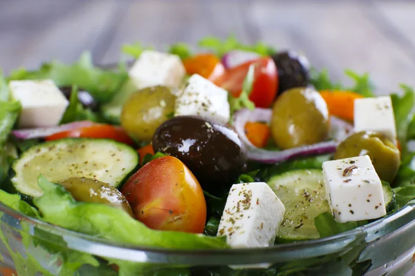 Греческий салат в стеклянной тарелке с вилкой, крупным планом — стоковое фото