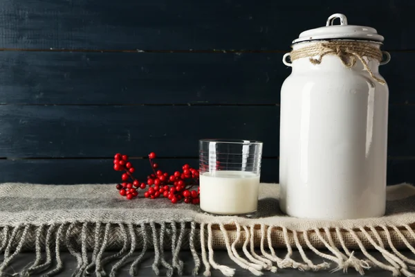 Lattina di latte e vetro con Rowan su sfondo di legno colore — Foto Stock