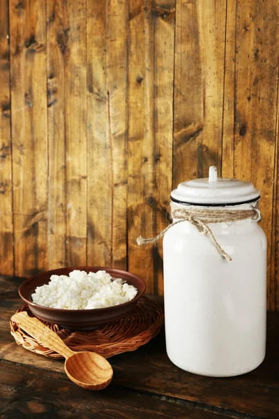 Latte può con ciotola di fiocchi di latte e cucchiaio su sfondo in legno rustico — Foto Stock