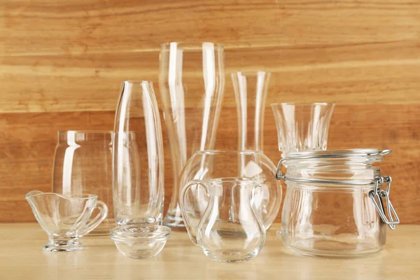 Різні скляні посуд на дерев'яному фоні — стокове фото