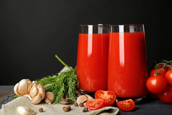 Kadeh tabloda gri arka plan üzerinde taze domates ve domates suyu — Stok fotoğraf