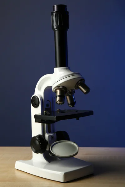 Микроскоп на столе, на цветном фоне — стоковое фото