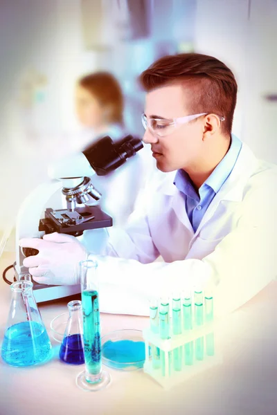 Joven investigador masculino que realiza investigación científica en laboratorio — Foto de Stock
