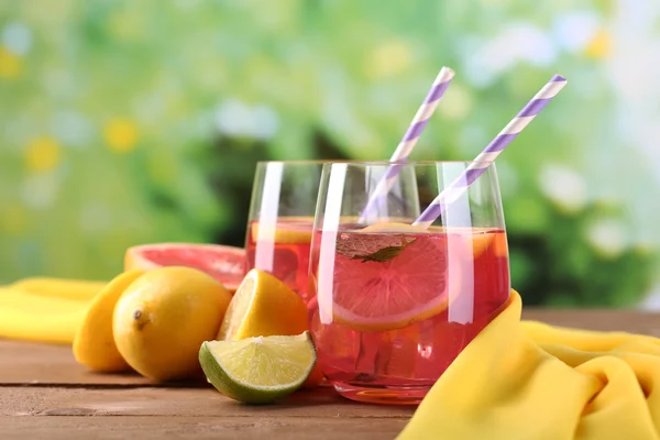 Рожевий лимонад в окулярах на столі на природному фоні — стокове фото