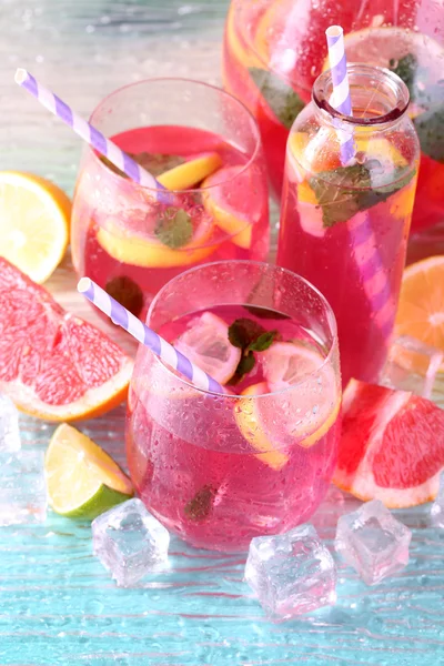 Rosa Limonade in Gläsern und Krug auf hellem Hintergrund — Stockfoto