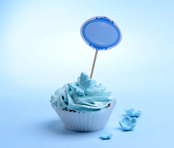 Delicious cupcake with inscription on table on blue background — Stock Photo, Image