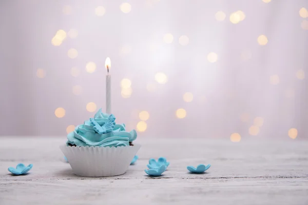 Delicioso cupcake de cumpleaños en la mesa sobre fondo claro —  Fotos de Stock