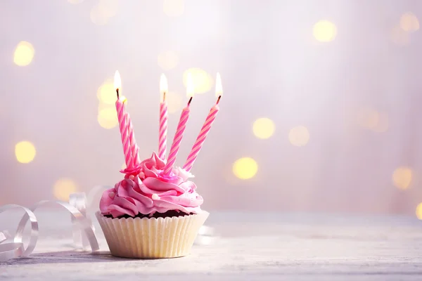 Delicioso cupcake de aniversário na mesa no fundo claro — Fotografia de Stock