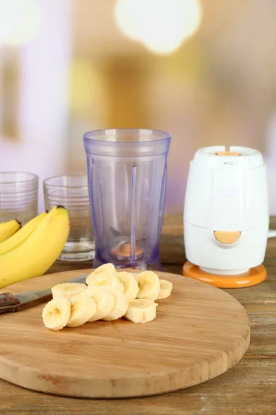 Gesneden bananen op snijplank, op houten tafel, op lichte achtergrond — Stockfoto