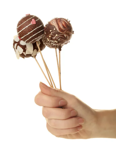 Weibliche Hand hält Cake Pops, isoliert auf weiß — Stockfoto