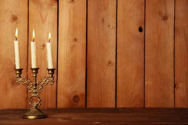 Retro candlestick with candles on wooden background — Stock Photo, Image