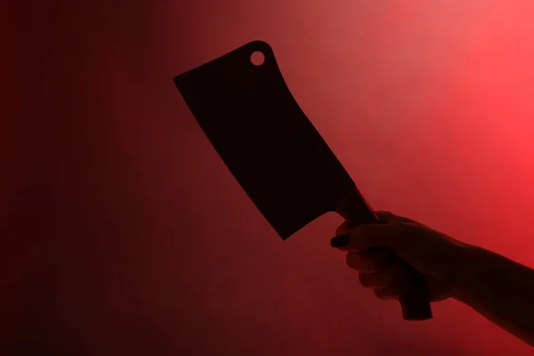 Cuchillo de mano femenino sobre fondo rojo — Foto de Stock