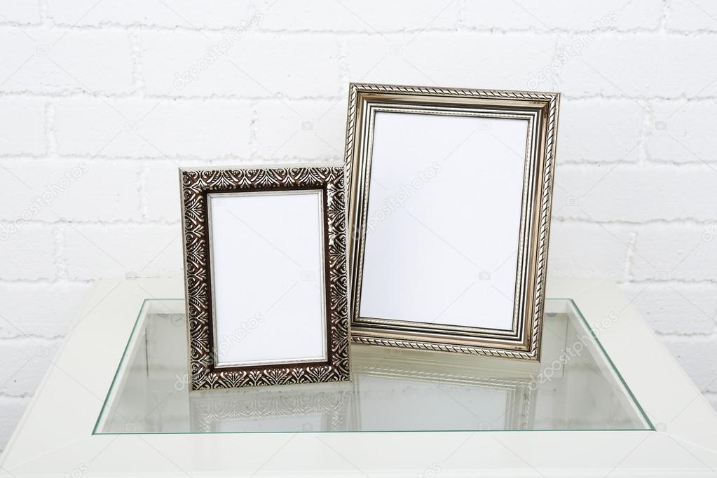 Photo frames on coffee table on brick wall background