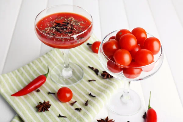 Suco de tomate em cálice e legumes frescos em guardanapo no fundo de madeira — Fotografia de Stock