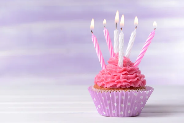 Delicious birthday cupcake on table on light purple background — Stock Photo, Image