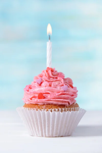 Νόστιμα γενέθλια cupcake στο τραπέζι σε γαλάζιο φόντο — Φωτογραφία Αρχείου