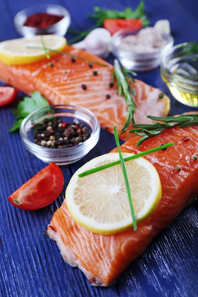 Fresh salmon with spices and lemon on wooden table — Stock Photo, Image