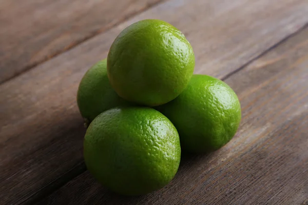 Fresh juicy limes on wooden background — Stock Photo, Image