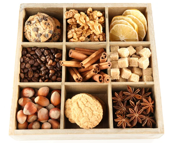 Caja cuadrada con galletas, frutos secos y especias aisladas en blanco —  Fotos de Stock