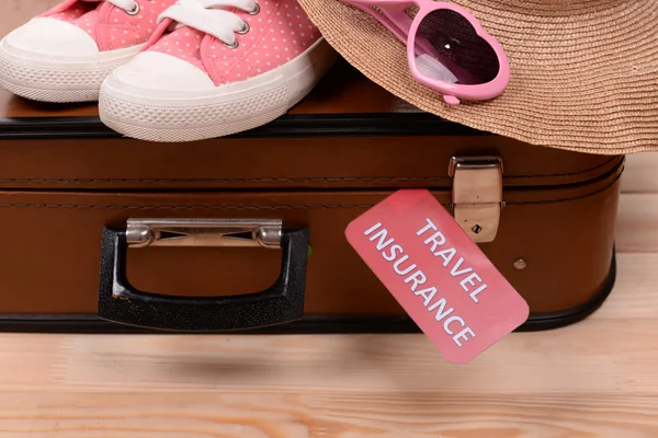 Koffer und Touristensachen mit Aufschrift Reiseversicherung auf Holzgrund — Stockfoto