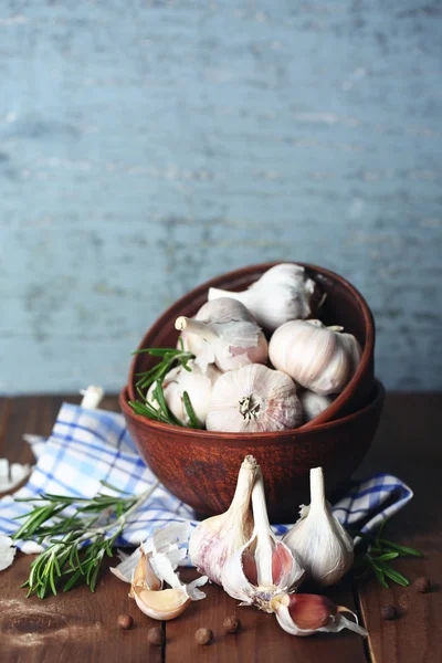 Rauwe knoflook en kruiden op houten tafel — Stockfoto