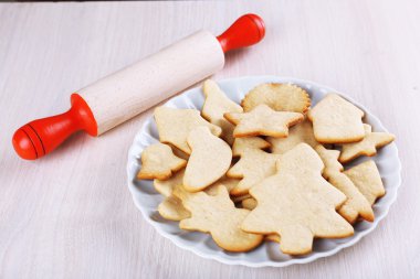 Ahşap masa arka plan üzerinde gingerbread çerezleri plaka bakır çerez kesici ve haddeleme pin