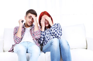 Genç çift, evde televizyon izlerken