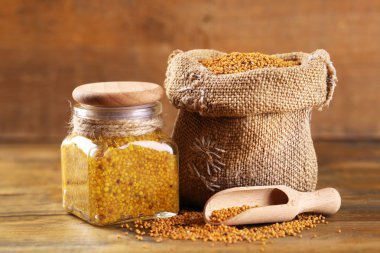 Ahşap arka plan üzerinde çantaya hardal tohumu ve Dijon hardalı Cam Kavanoz