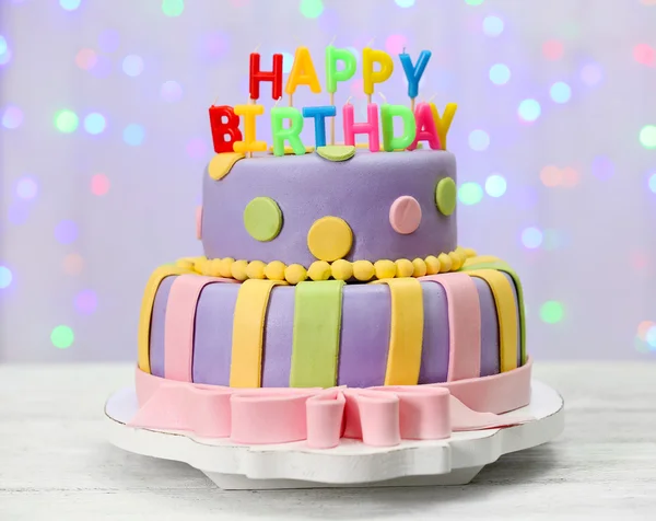 Delicious birthday cake on shiny light background — Stock Photo, Image
