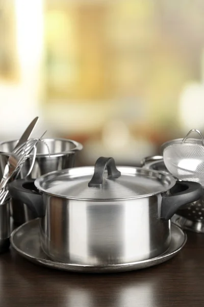 Utensili da cucina in acciaio inox su tavolo, su sfondo chiaro — Foto Stock