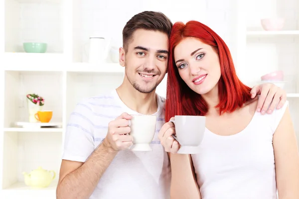 Happy couple drinking tea in kitchen — Stock Photo, Image