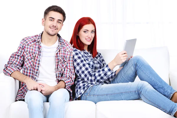 Jong koppel zitten in Bank met laptops in de kamer — Stockfoto