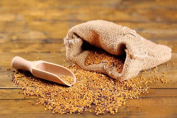 Semillas de mostaza en bolsa sobre fondo de madera — Foto de Stock