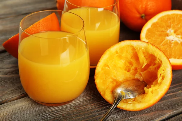 Glas Orangensaft mit Scheiben auf rustikalem Holztischhintergrund — Stockfoto