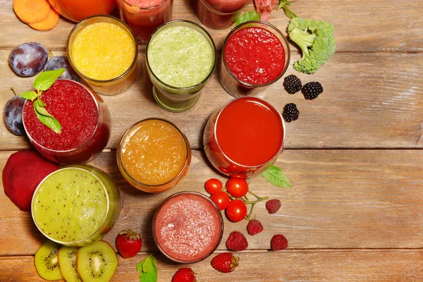 Gläser mit leckerem frischen Saft, auf Holztisch. — Stockfoto