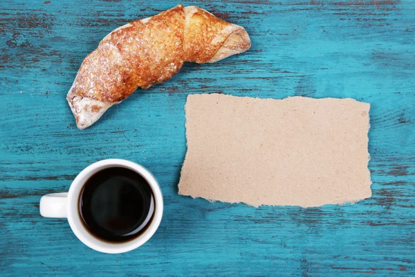 Composition of coffee, fresh croissant and paper card on wooden background — Stock Photo, Image