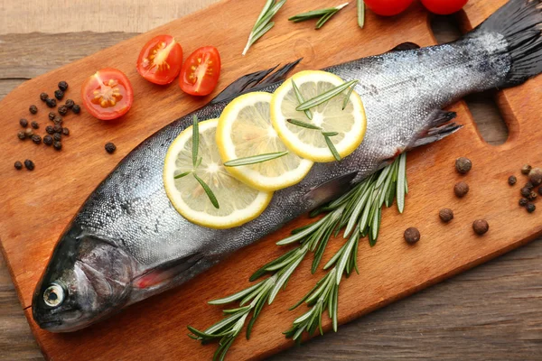 Verse rauwe vis en voedselingrediënten op tafel — Stockfoto