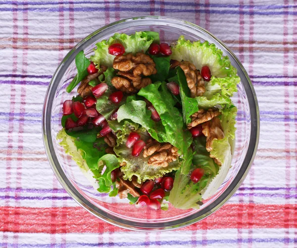 Fresh salad with greens, garnet and spices on plate on table close-up — Stock Photo, Image