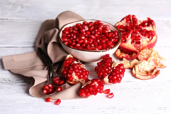 Beautiful composition with juicy  pomegranate seeds, on old wooden table — Stock Photo, Image