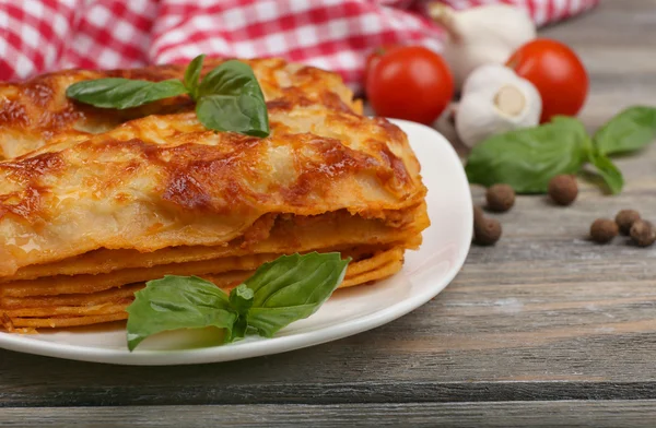 Portion de lasagnes savoureuses sur table en bois — Photo