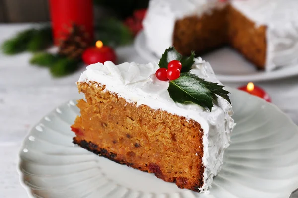 Rebanada de crema cubierta de pastel con decoración de Navidad en la mesa, sobre fondo de pared de madera —  Fotos de Stock