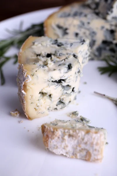 Blue cheese with sprigs of rosemary on plate, closeup view — Stock Photo, Image