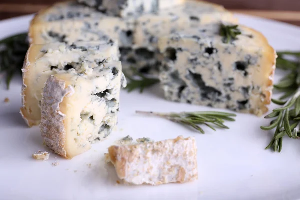 Blue cheese with sprigs of rosemary on plate, closeup view — Stock Photo, Image