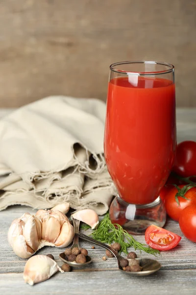 Vaso de sabroso jugo de tomate y tomates frescos sobre mesa de madera —  Fotos de Stock