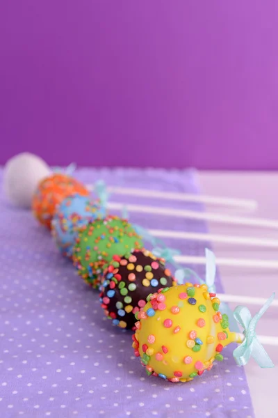 Süße Cake Pops auf dem Tisch auf lila Hintergrund — Stockfoto