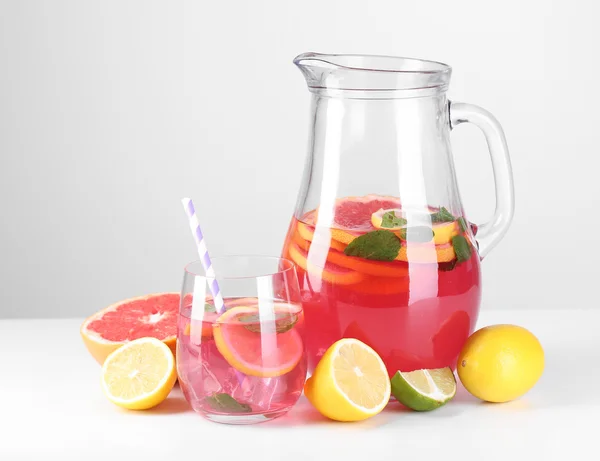 Pink lemonade in glass and pitcher isolated on white — Stock Photo, Image