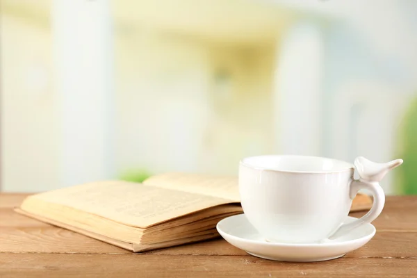 Cup and book on table — Stock Photo, Image