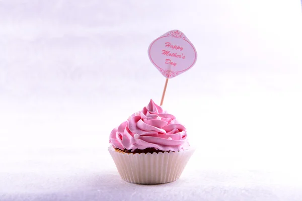 Delicioso cupcake com inscrição na mesa em fundo bege — Fotografia de Stock